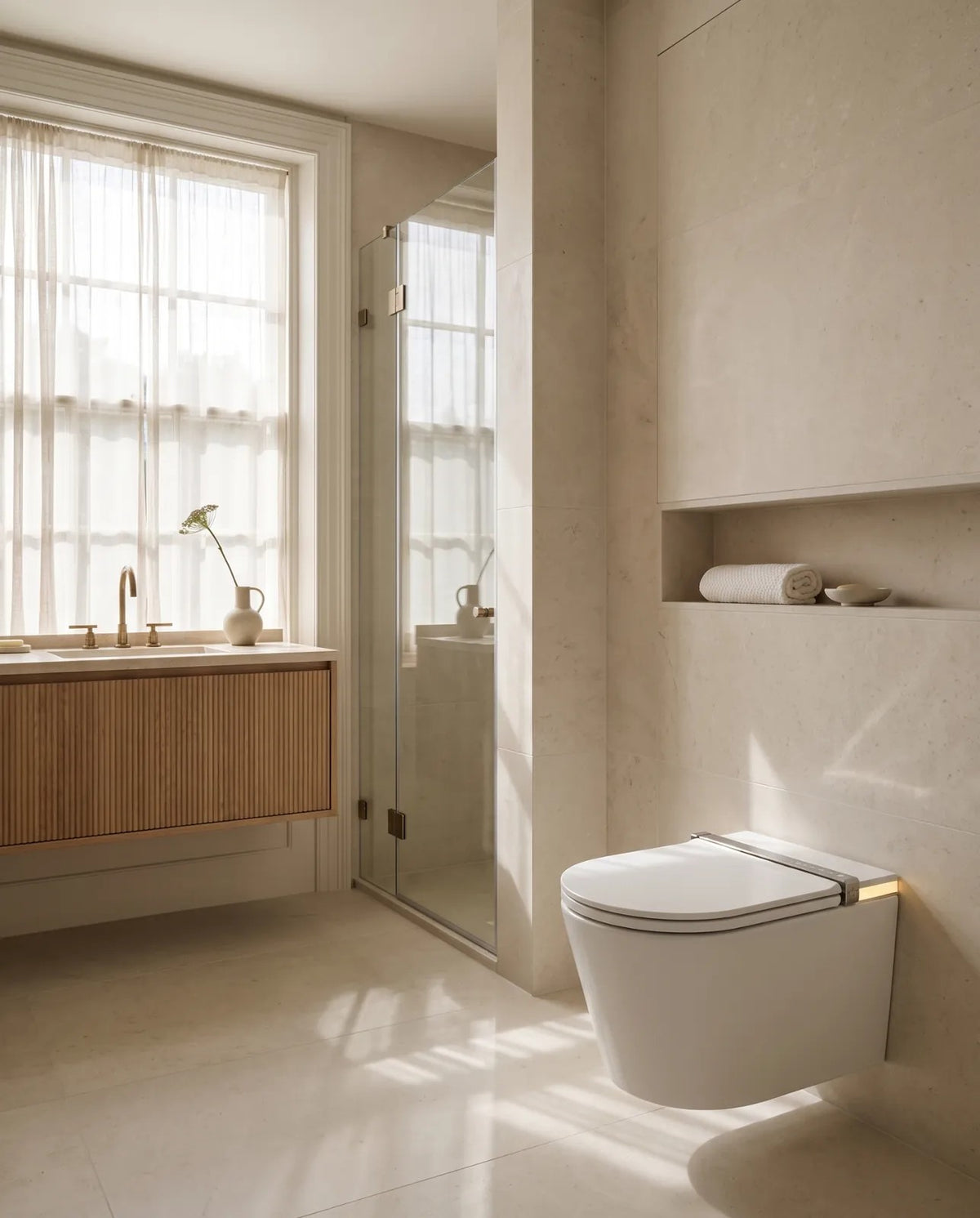 Clair wall-hung smart toilet in a sunlit limestone bathroom